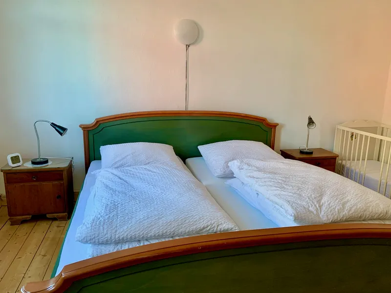 Schlafzimmer mit Doppelbett, Babybett und Wickelkommode